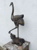 Life-size bronze statue of crane bird on the turtle's back