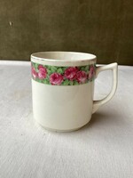 Old porcelain mug with rose pattern.