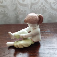 Little girl pulling on Aquincum trousers porcelain nipp