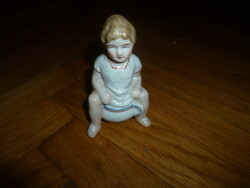 Antique small porcelain bush boy sitting on a bilin