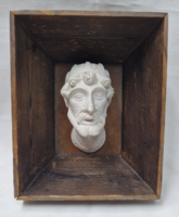 Old plaster head, portrait in a wooden frame