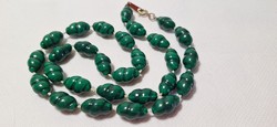 Green string of beads with a twist pattern