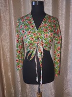 S-shaped floral top with bell sleeves. Novel