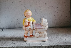 Antique charming porcelain figure of a little girl with a pram