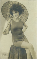 1928 - Full-length photo of a young woman in a contemporary, elegant bathing suit with a parasol. Original
