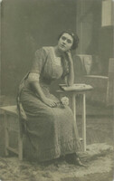 Cca 1920 – Középosztálybeli, fiatal nő virággal. Műtermi felvétel, fotólap.