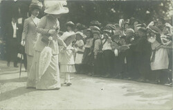 1912 - A distinguished lady with her granddaughter at an event among children.