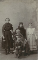 Early 1900s. Young mother with children, studio shot. Its maker is unknown.