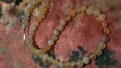 49 cm necklace made of slightly brownish-pink mineral pearls, in good condition.