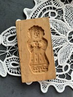 A traditional wooden gingerbread cookie cutter in the shape of a honey doll