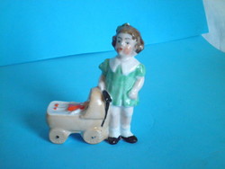 Old German porcelain figurine of a little girl with a pram