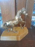 Copper-bronze Paripa horse figural sculpture, on a wooden pedestal.