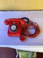 Régi működő piros tárcsás telefon.