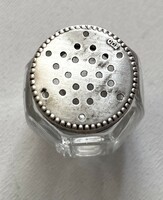 Small glass salt shaker with a silver top