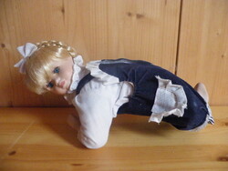Porcelán bájos arcú, fekvő baba (fej, alkar, lábszár), aranyos ruhában