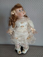 Csodálkozó arcú porcelán baba állvánnyal