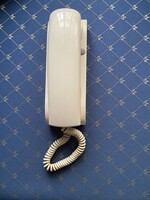 Fehér,teljesen új,falra szerelhető vonalas telefon. Mérete:24 cm x 7 cm