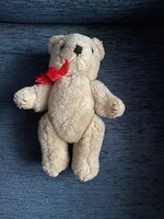 Aranyos kis halvány drapp plüss Maci. Mozgatható kezekkel,lábakkal. Piros masnival.Új állapotban.