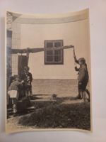 Régi fekete-fehér fotó, gyerekek játszanak a gémeskútnál- Ausztria 1950-es évek