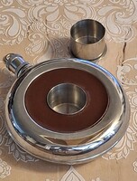 Round-shaped drink flask in the center with small shot glass , with glass , with fastening clasp with leather decoration