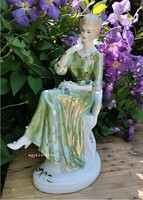Széken ülő nő zöld ruhában nagy méretű porcelán