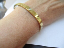 Szép, újszerű aranyozott karkötő fehér kövekkel.