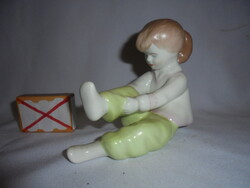 Aquincumi porcelán cipőjét kötöző lány figura, nipp