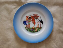Porcelán lapos tányér H&C Chodau gyermek tányér amelyen gyerekek gólya kiskacsák és egy esernyő van