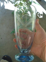 Halványkék színű talpas Kosta üvegváza, melyen repülő sas gravírozás látható, súlya 532 gramm