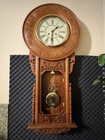 Falióra, kézzel faragott ﻿díszítéssel, feles ütős szerkezettel.