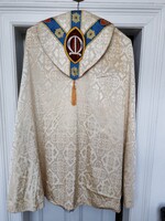 Fehér brokát, részben bársonnyal applikált, és gyönggyel hímzett papi palást, liturgikus textil.
