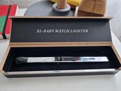 Gyufa alakú, fényes fémszínű öngyújtó, fekete fejjel, elegáns saját dobozában, mérete 17,5cm