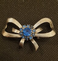 Vintage masni alakú ezüst színű, kék kristályokkal díszített bross kitűző