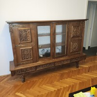 Faragott fa vitrines szekrény, középen üveg ajtókkal, réz díszítéssel