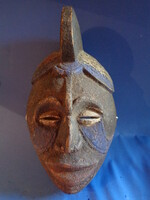 Fából készült afrikai törzsi maszk látható, amelyet kézzel festettek.