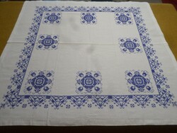 Keresztszemes kék hímzett mintás azsúros szélű terítő.