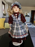 Vintage gyűjtői porcelán fejű, kezű, lábú baba skót kockás ruhában, állvánnyal (kb.40 cm)