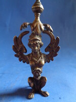 Szárnyas női busta (szfinx/hárpia jellegű klasszicizáló alak), stilizált növényi díszítéssel és akan