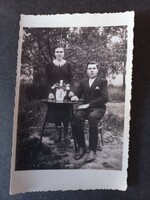 Régi fotó fiatal pár ünnepi ruhában virágos asztal mellett 1930 körül