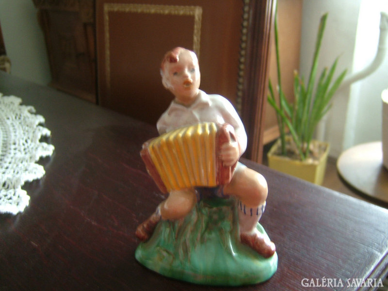 Antique ceramic statue: a child with a tango harmonica