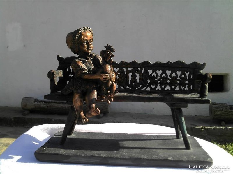 Bronze statue of a girl from Hollókő with a rooster
