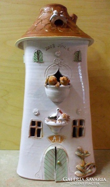 Ceramic house for a wedding present and baby birth with the young couple, baby and stork