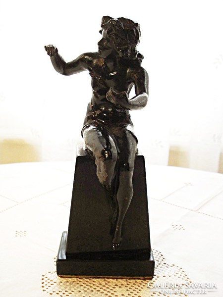 Üldögélő fiatal hölgy, szecessziós  szobor, fekete márvány talapzaton.
