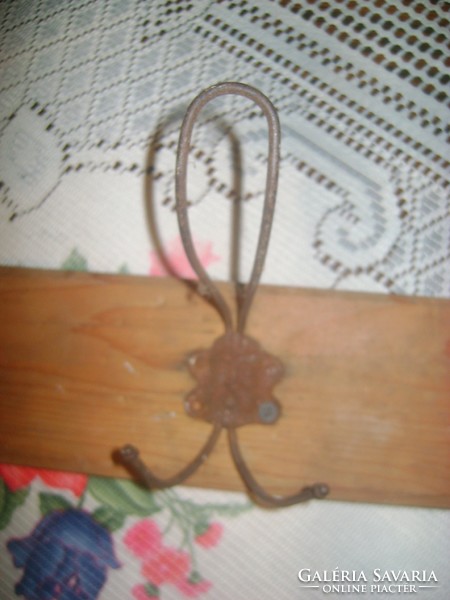 Old metal-wooden wall hanger with convex head motifs