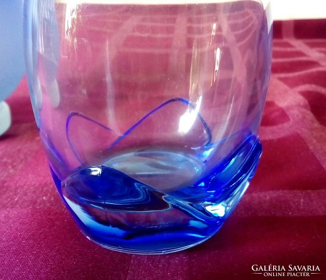 Special glass vase with blue flower petals at the bottom