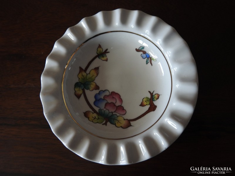 A centerpiece serving bowl with a floral design with a ribbed rim