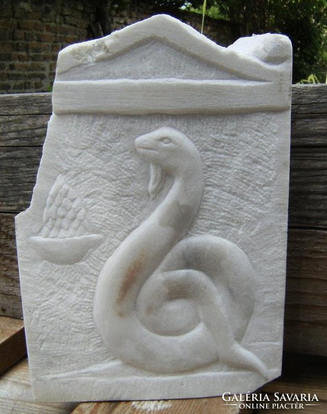 Stone carving relief of Greek snake demon from Carrara marble