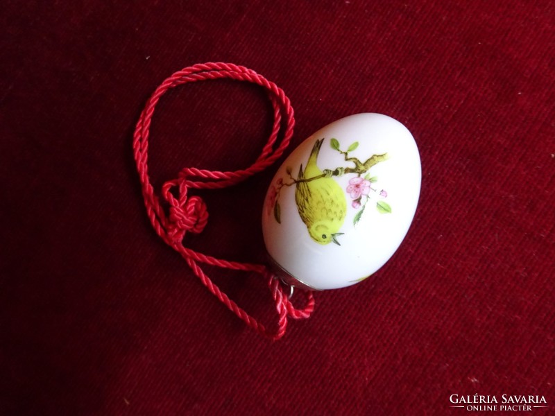 Porcelain egg with bird motif. With hanging cord. He has!
