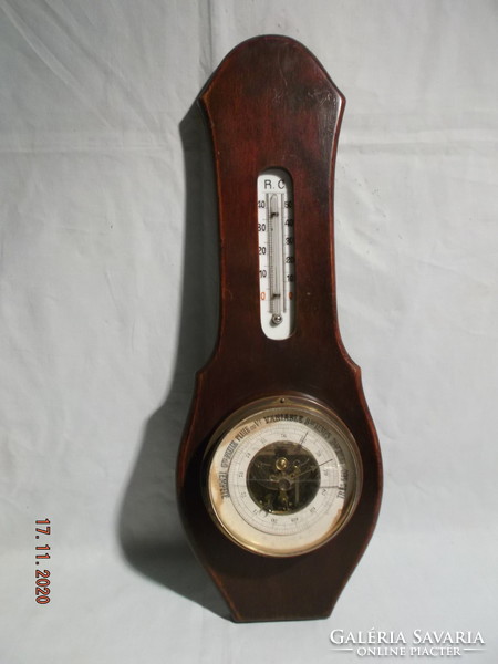 Old thermometer and barometer in a wooden case that can be hung on a wall.