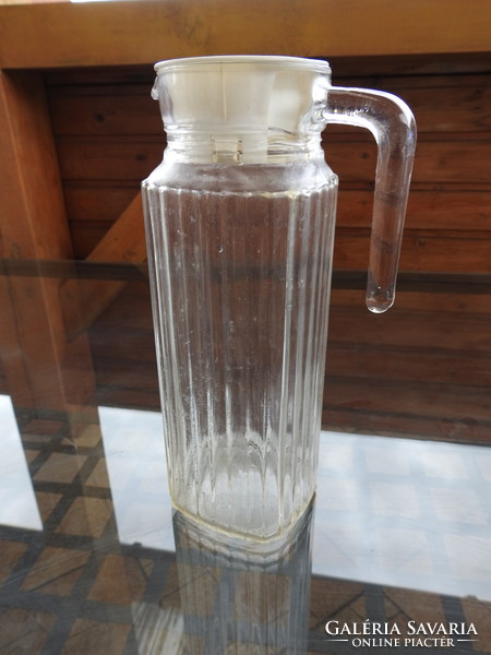 Old ribbed glass jug with plastic stopper